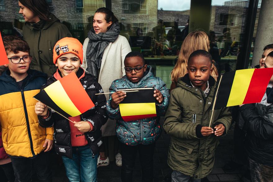 De kinderen wachten de Koningin op met vlaggetjes