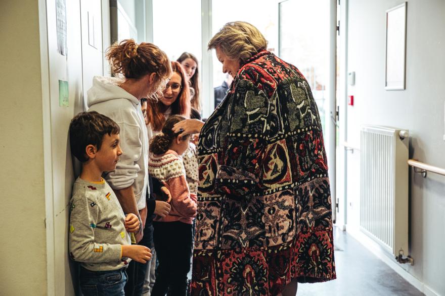 De Koningin groet de kinderen bij het buitengaan